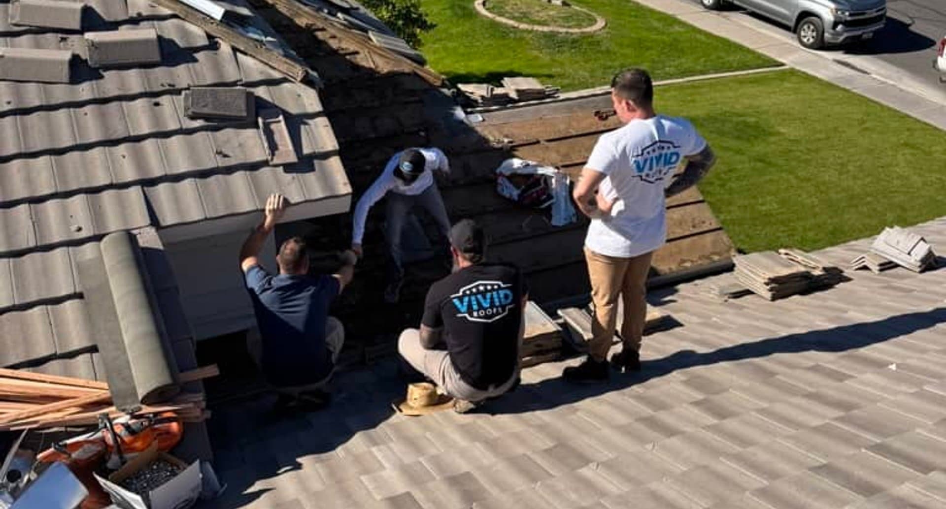 Roofing crew installing dark metal panels